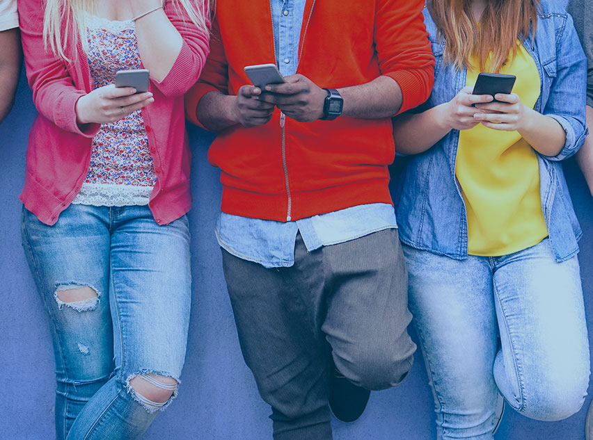 Abbildung von drei Jugendlichen mit Smartphones im Anschnitt